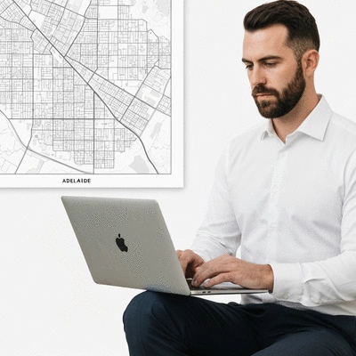 Person using a laptop to research property investments, with a map of Adelaide in the background, clean image
